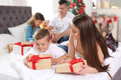 Photo of Happy parents and children exchanging gifts on Christmas morning at home