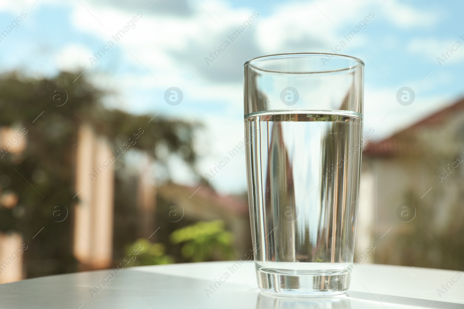 Photo of Glass of fresh water on table outdoors. Space for text