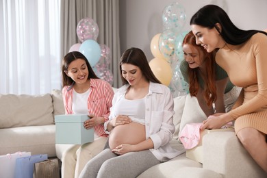 Happy pregnant woman spending time with friends at baby shower party