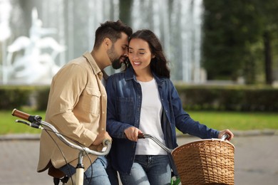 Beautiful couple with bicycles spending time together in park