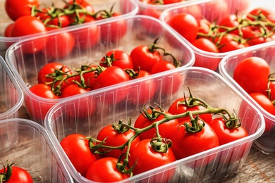 Photo of Fresh ripe red tomatoes in plastic containers