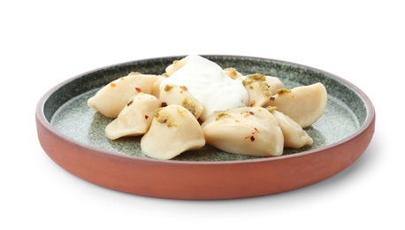 Photo of Delicious cooked dumplings with sour cream on white background