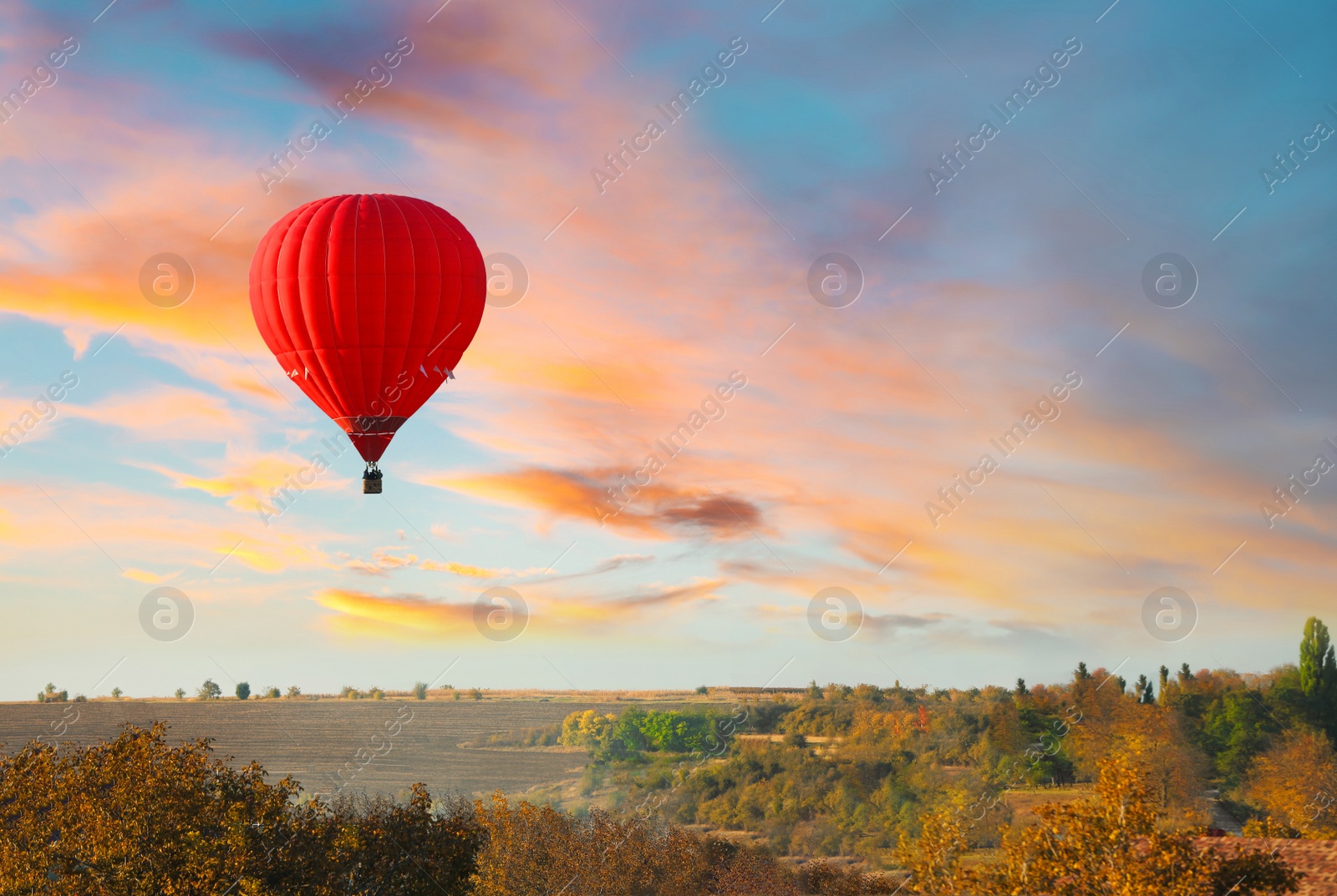 Photo of Colorful hot air balloon flying over countryside. Space for text