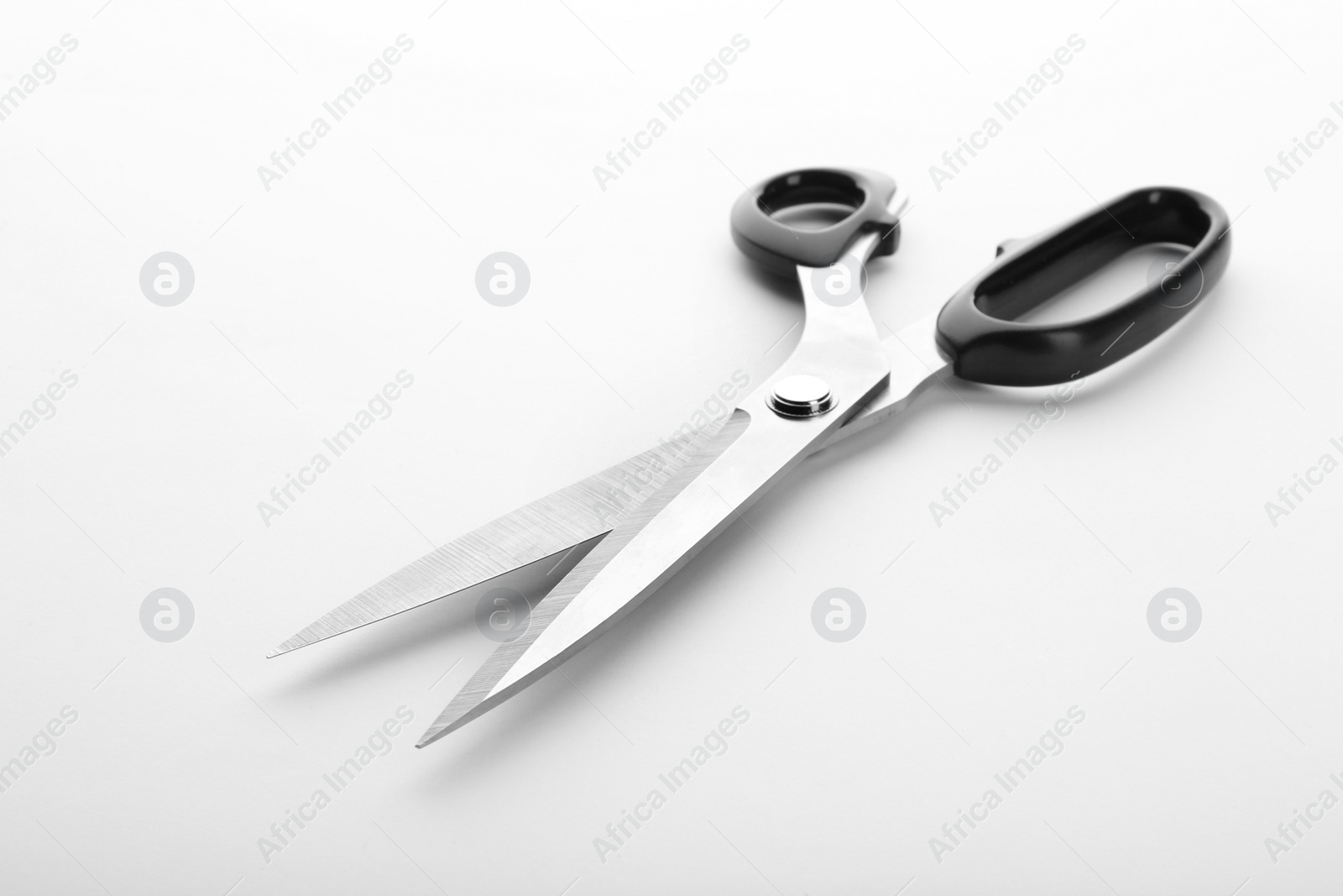 Photo of Pair of sharp sewing scissors on white background