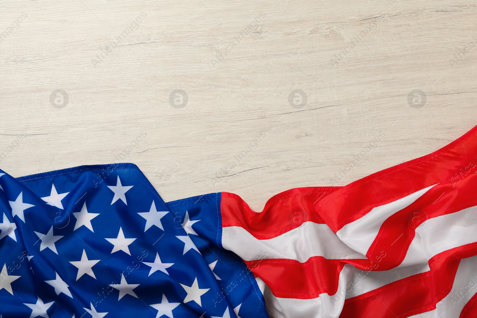 Photo of American flag on white wooden table, top view with space for text. Memorial Day