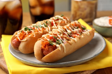 Photo of Delicious hot dogs with bacon, carrot and parsley on table, closeup