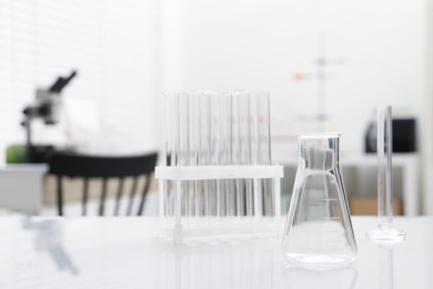 Photo of Laboratory analysis. Flask and test tubes on white table indoors