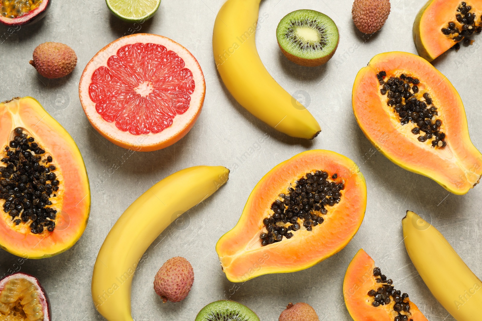 Photo of Fresh ripe papaya and other fruits on light grey table, flat lay