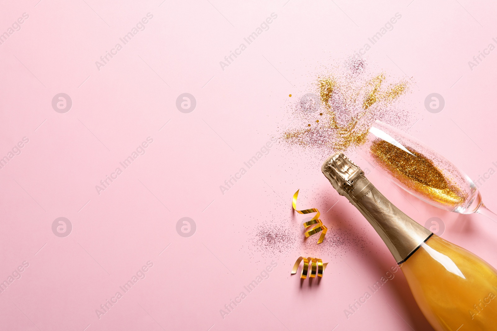 Photo of Flat lay composition with bottle of champagne for celebration on pink background. Space for text