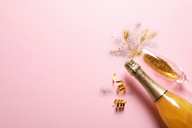 Photo of Flat lay composition with bottle of champagne for celebration on pink background. Space for text