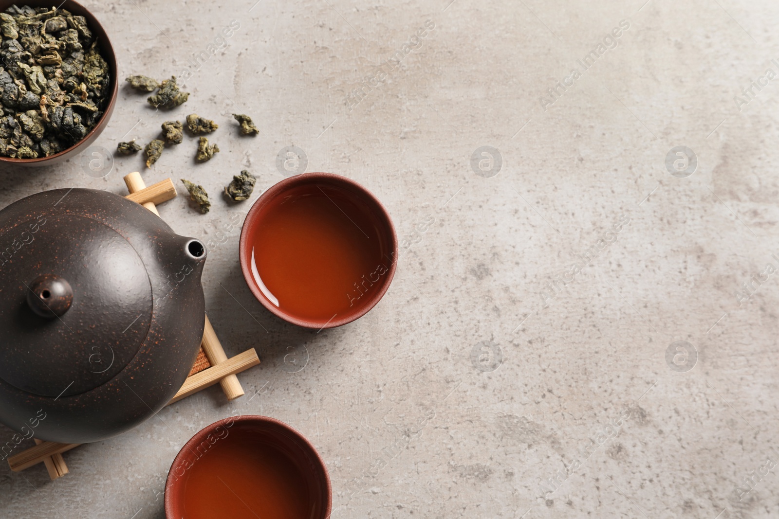 Photo of Flat lay composition with cups of Tie Guan Yin oolong tea and space for text on table