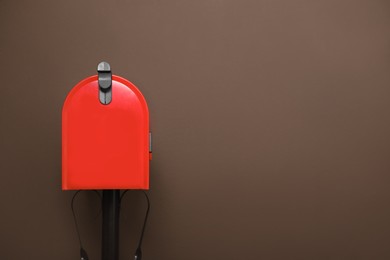 Photo of Closed red letter box against brown background. Space for text