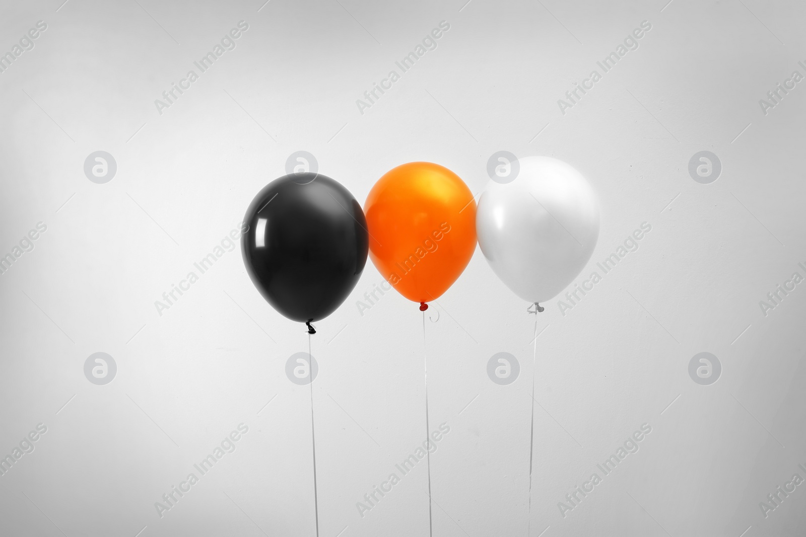 Photo of Colorful balloons on light background. Halloween party