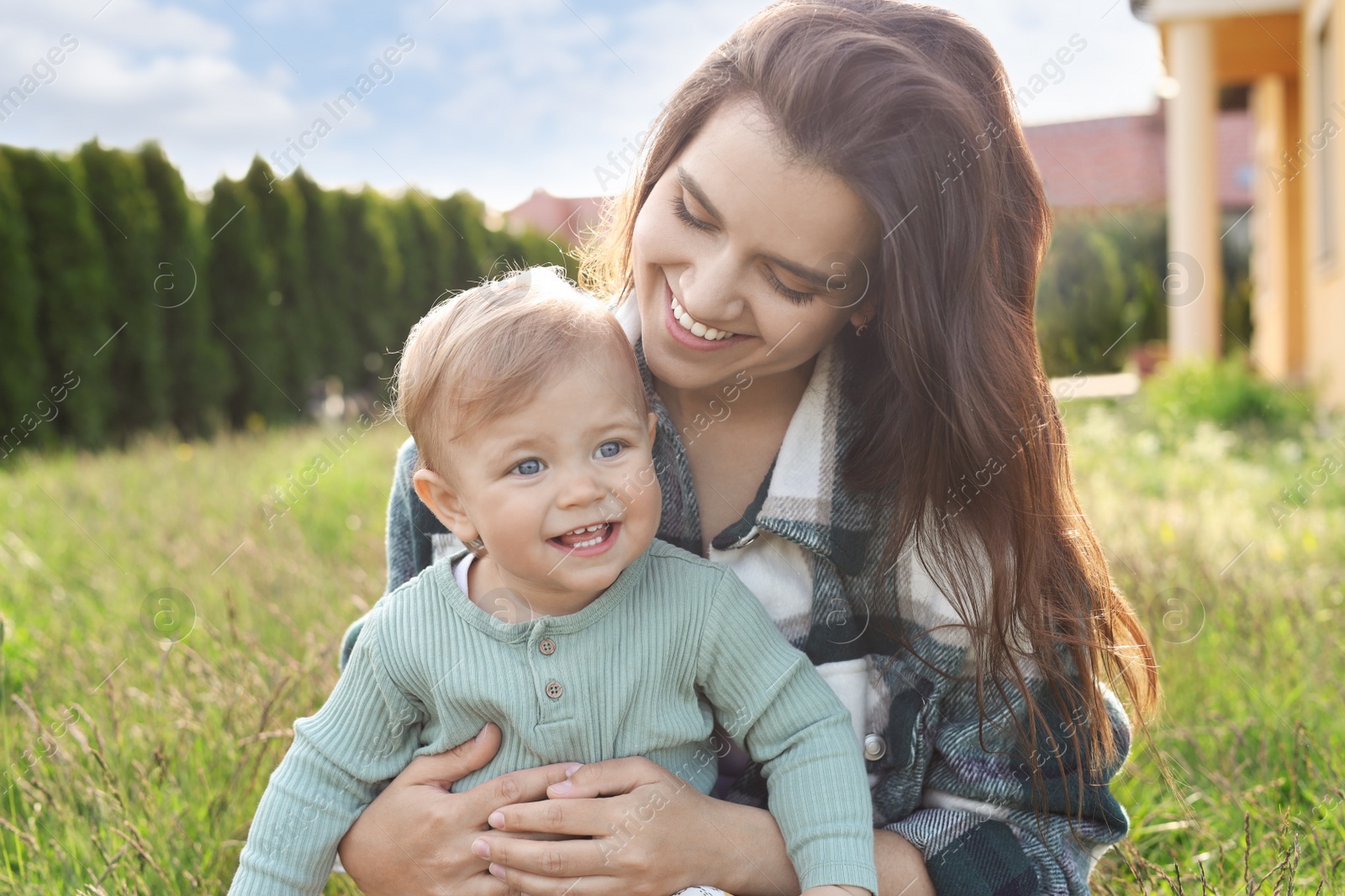 Photo of Happy mother with her cute baby at backyard on sunny day