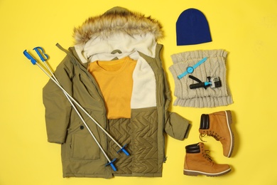 Photo of Flat lay composition with warm female clothes for winter vacation on color background