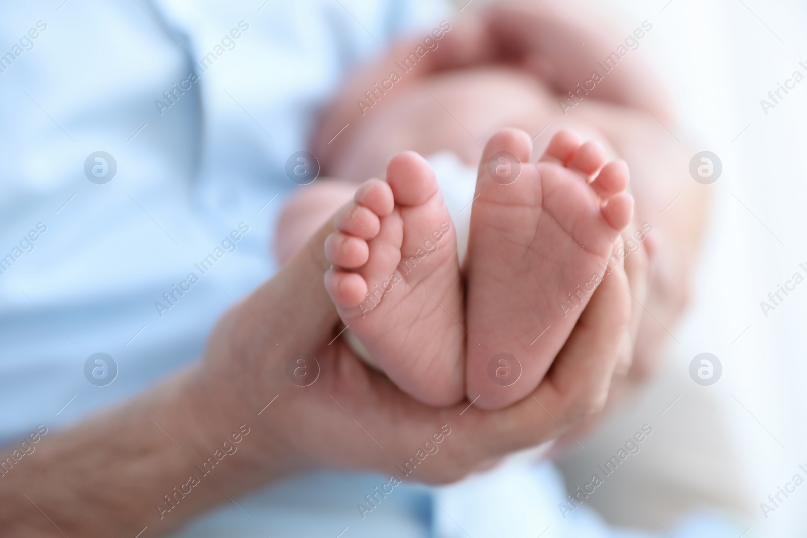 Photo of Father holding his newborn baby at home, closeup