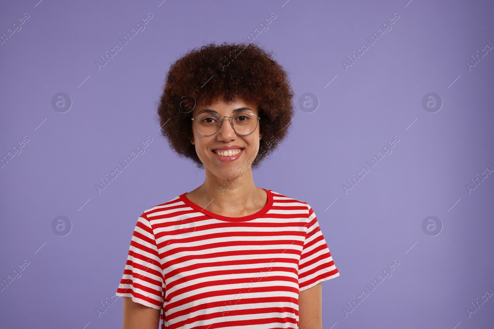 Photo of Portrait of happy young woman in eyeglasses on purple background. Space for text