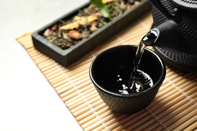 Photo of Pouring green tea into cup on table. Space for text