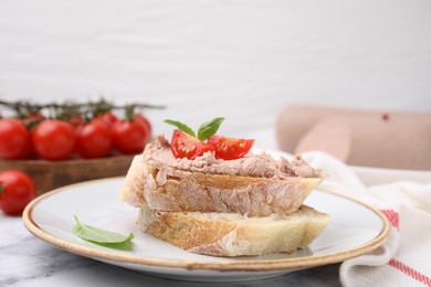 Photo of Delicious liverwurst sandwich with tomatoes and basil on white marble table, closeup