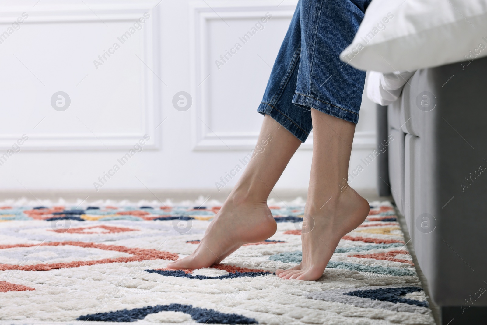 Photo of Woman on carpet with pattern at home, closeup. Space for text