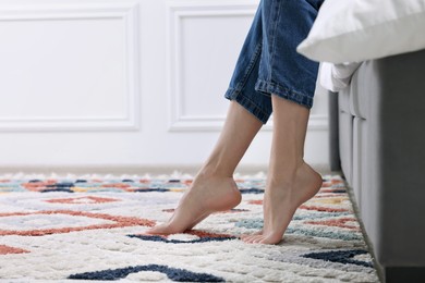 Photo of Woman on carpet with pattern at home, closeup. Space for text