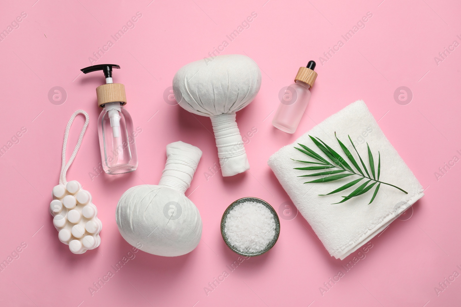 Photo of Beautiful spa composition with herbal massage bags and different care products on pink background, flat lay