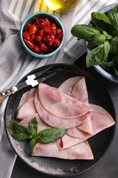 Photo of Tasty ham with basil, pickled peppers and carving fork on table, flat lay
