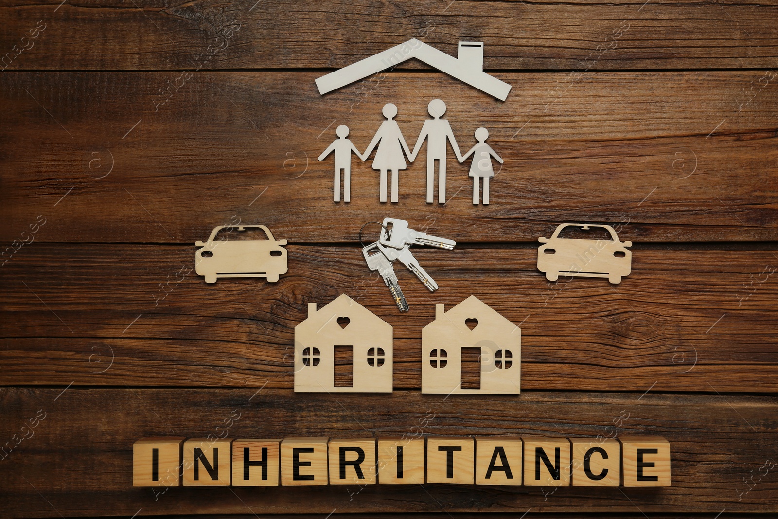 Photo of Word Inheritance made with cubes and different cutouts on wooden background, flat lay