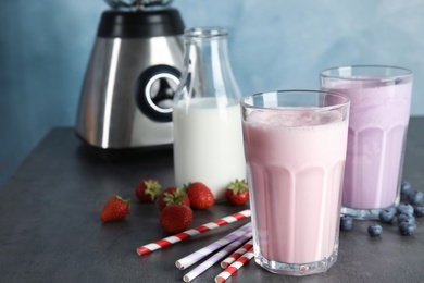 Photo of Delicious milk shakes and ingredients on table