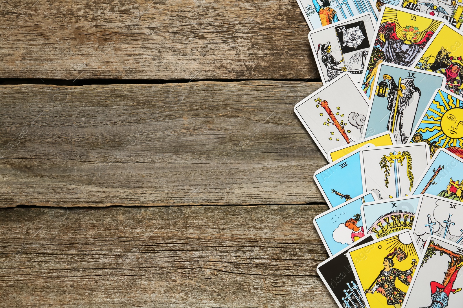 Photo of Tarot cards on wooden table, top view. Space for text