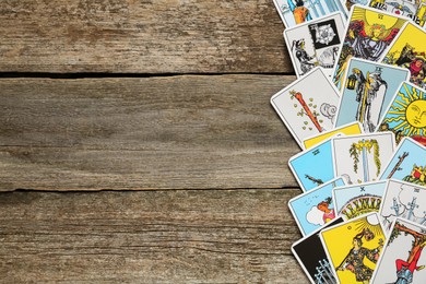 Tarot cards on wooden table, top view. Space for text