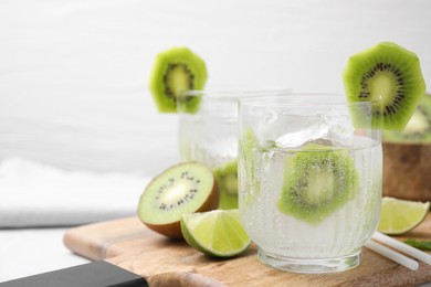 Photo of Refreshing drink, cut kiwi and lime on table. Space for text