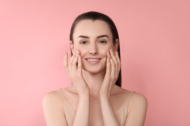 Portrait of beautiful young woman on pink background