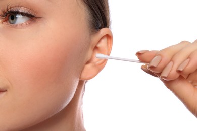 Photo of Young woman cleaning ear with cotton swab on white background, closeup