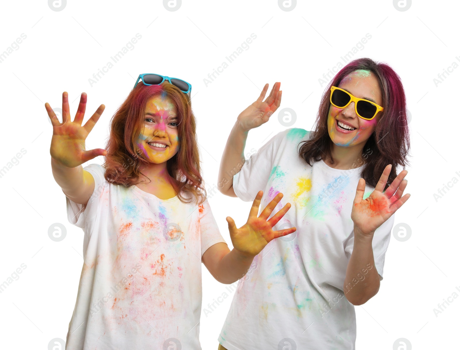 Photo of Woman and teen girl covered with colorful powder dyes on white background. Holi festival celebration