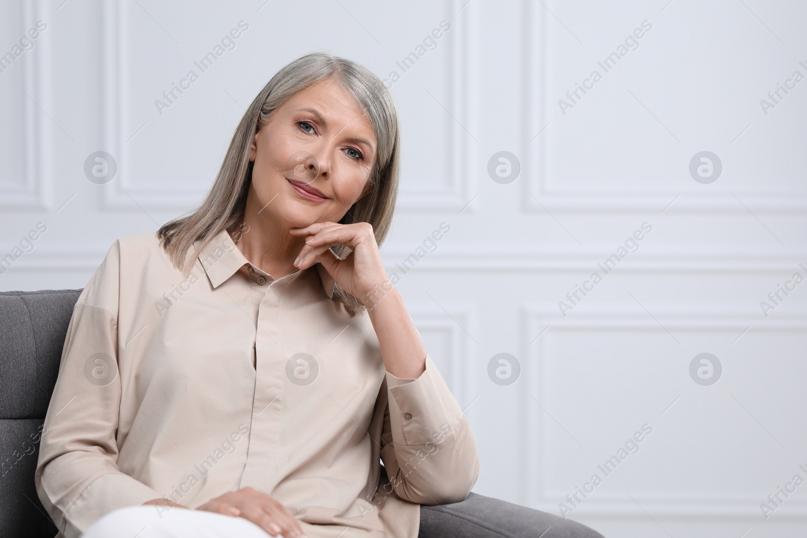 Photo of Portrait of beautiful senior woman in armchair indoors. Space for text