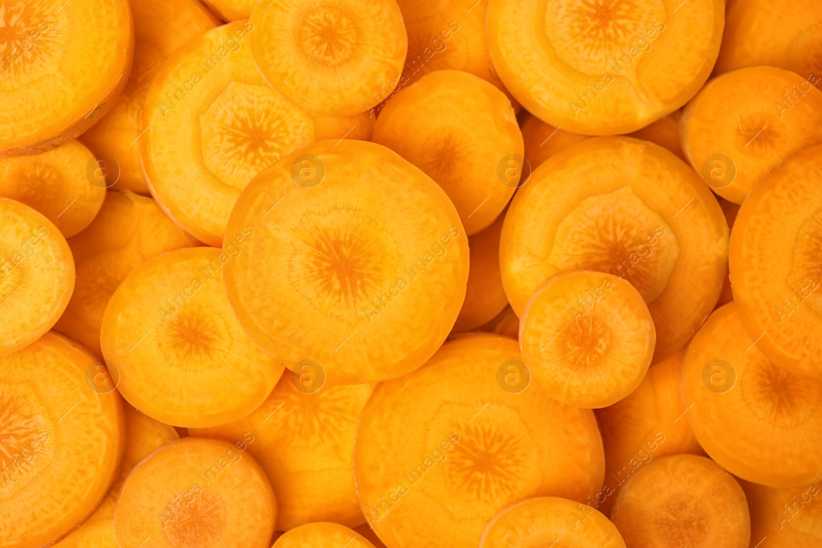 Photo of Slices of fresh ripe carrots as background, top view