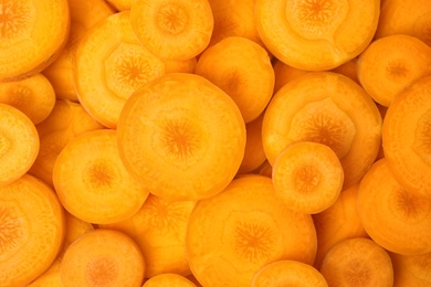 Photo of Slices of fresh ripe carrots as background, top view