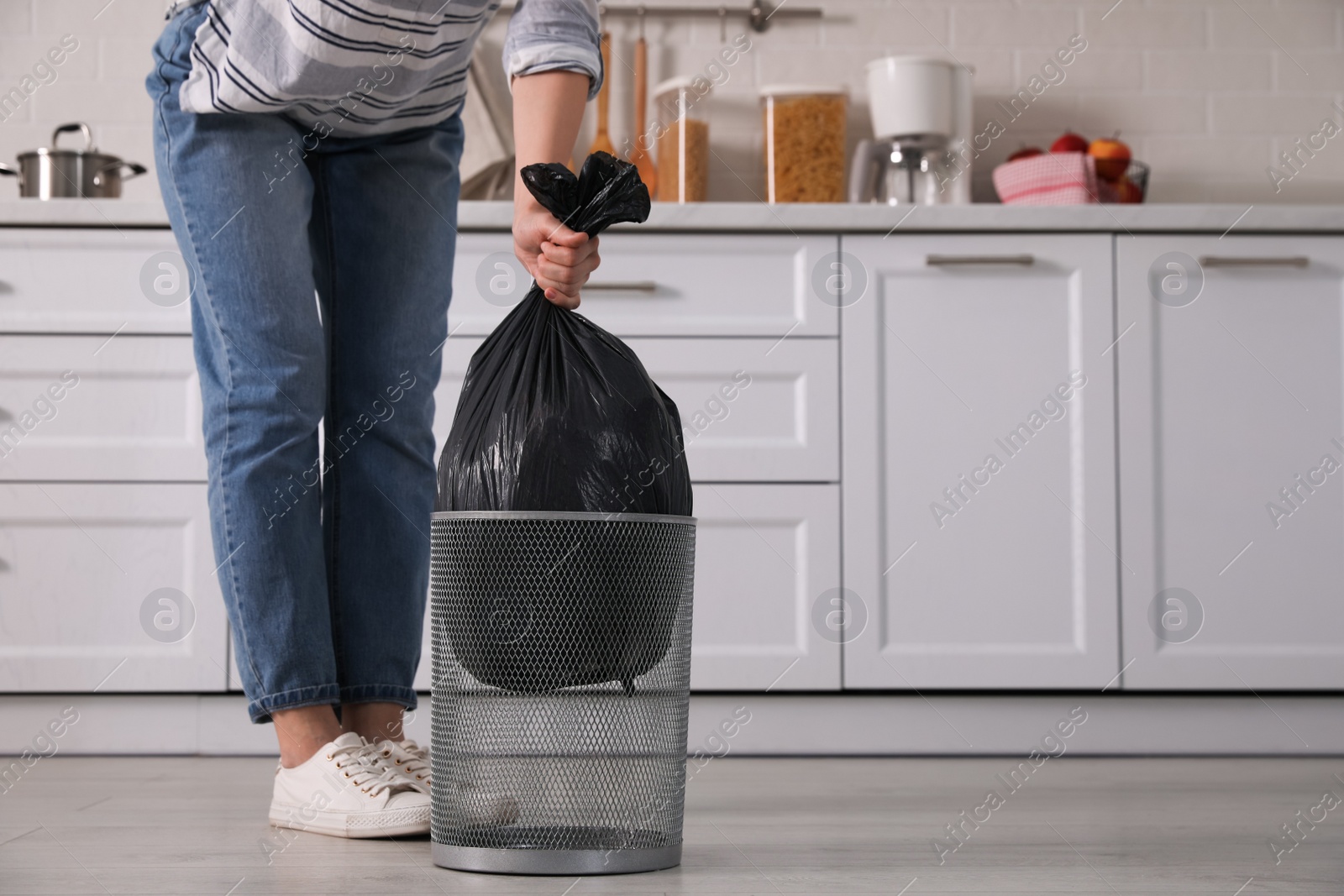 Photo of Woman taking garbage bag out of bin at home, closeup
