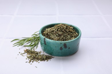 Photo of Dry and fresh tarragon on white tiled table