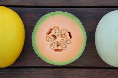 Different types of tasty ripe melons on wooden table, flat lay