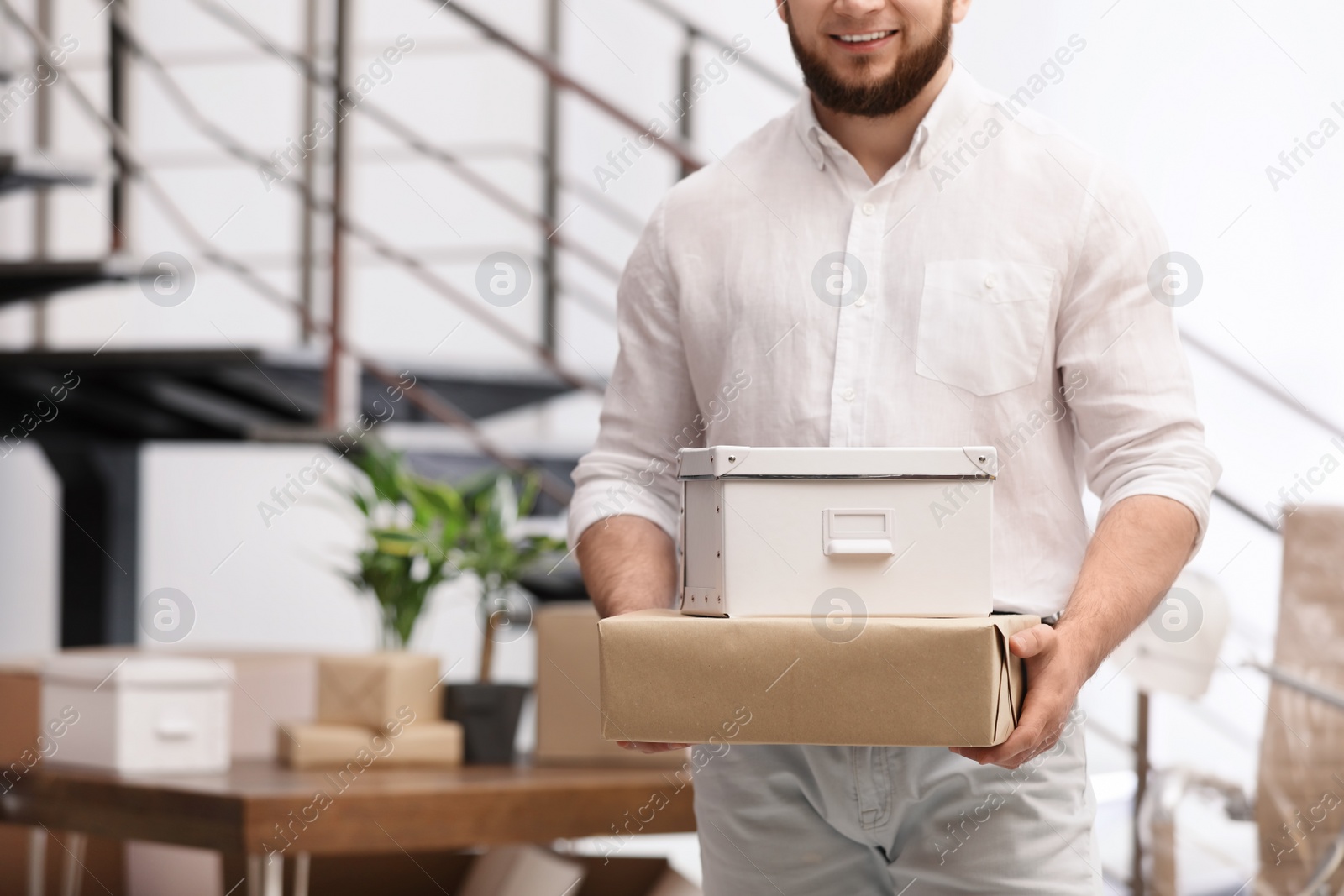 Photo of Man holding moving boxes in new office, closeup. Space for text