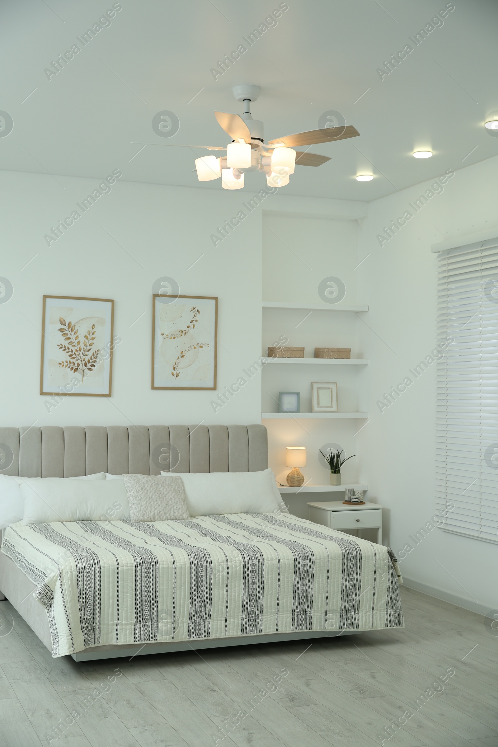 Photo of Comfortable furniture, ceiling fan and accessories in stylish bedroom