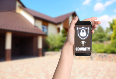 Image of Alarm system. Woman using phone outdoors, space for text