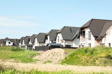 Photo of Many houses with grey roofs outdoors on sunny day