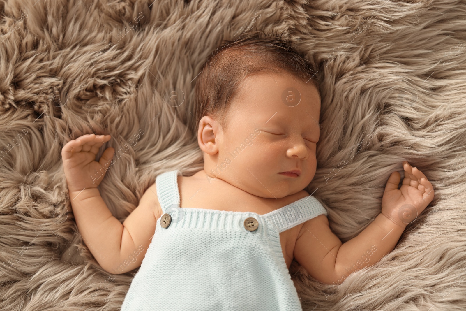 Photo of Cute newborn baby sleeping on fluffy blanket, top view