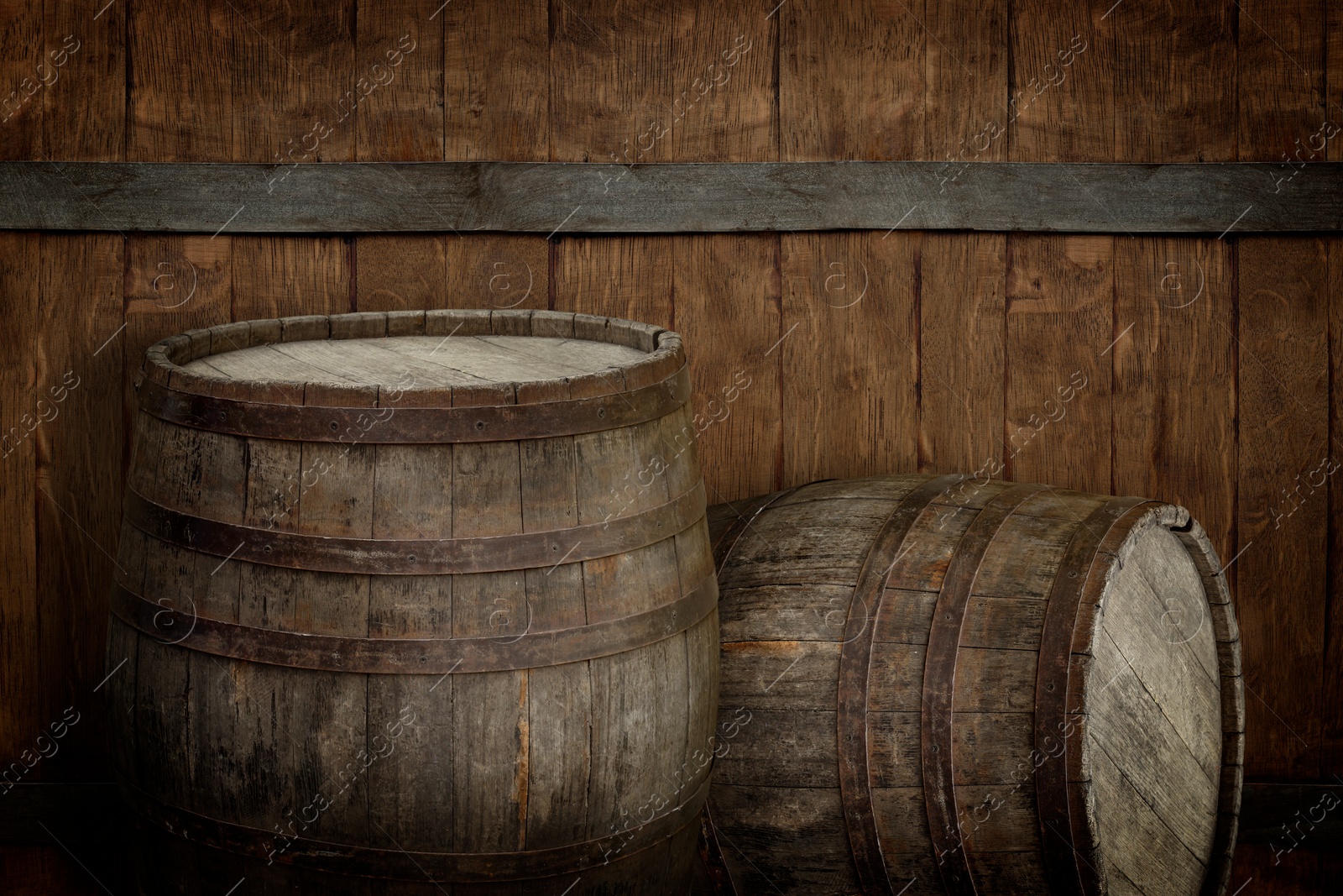 Image of Two wooden barrels near brown textured wall