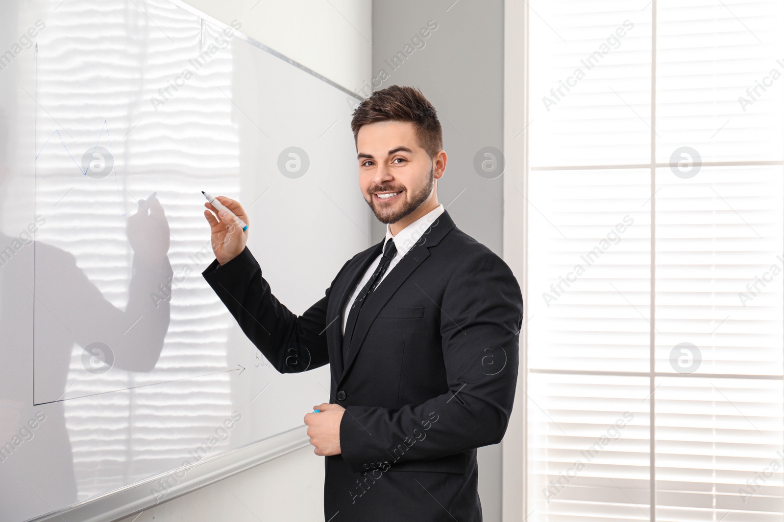 Photo of Professional business trainer near whiteboard in office