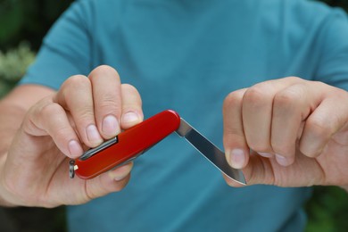 Photo of Man holding compact portable multitool, closeup view