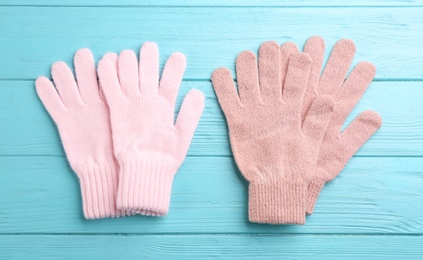 Stylish gloves on turquoise wooden background, flat lay